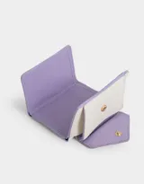 Billetera pequeña de cuerina color rosa claro con solapa en forma de sobre y broche de corazón dorado.