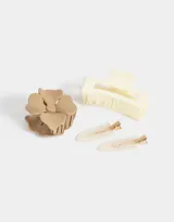 Set de accesorios para el pelo que incluye dos hebillas tipo pico de pato con diseño de resina marmolada, un broche con forma de flor color beige y un broche rectangular color crema.