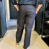 Pantalón de lino color azul marino, de corte recto y diseño minimalista. Presenta cierre frontal con botón y cremallera, bolsillos laterales y presillas para cinturón.