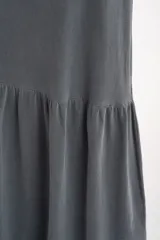 Vestido largo gris de algodón con breteles finos y falda con volado.