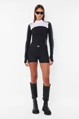 Top deportivo negro de tricot con recortes pisados con bordador, media polera, manga larga con mitones y estampa en lateral del frente y espalda.