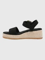 Sandalias negras con plataforma de yute, tira ancha sobre los dedos y tira con hebilla dorada alrededor del tobillo.