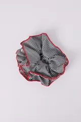 Scrunchie para el pelo con estampado de cuadros vichy en blanco y negro, con borde de crochet rojo.