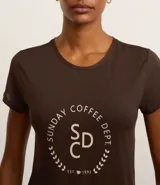 Remera deportiva marrón de microfibra texturizada, con cuello redondo, mangas cortas y estampa frontal con el texto "Sunday Coffee Dept.".