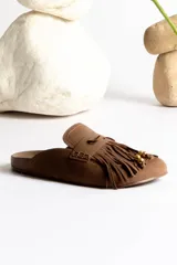 Mules color marrón con detalle de flecos y apliques dorados.