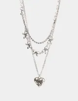 Collar corto plateado de tres capas: una de strass, otra con dijes de moños y una tercera con un dije de corazón con detalles grabados.