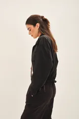 Campera negra con jareta ajustable en el ruedo con cordón de colores, presilla interna en las mangas y bolsillos en el delantero.
