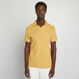 Remera amarilla de punto de piqué con cuello polo y mangas cortas.