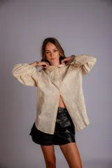 Camisa celeste con bordado de flores blancas, de manga larga abullonada.