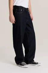 Pantalón de jean azul oscuro, corte amplio, con bolsillos delanteros y traseros.