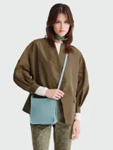 Bandolera Longchamp modelo Le Foulonné, color celeste, de cuero granulado, con correa fina ajustable y logo grabado en el frente.