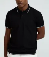 Remera polo blanca de media malla texturizada a rayas, corte regular, con cuello y mangas cortas en ribana con detalle contrastante en negro.