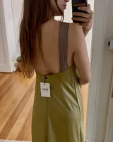 Vestido midi color marrón con brillo, escote en pico con borde dorado y tajo frontal.