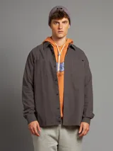 Camisa de corte clásico, de color gris oscuro, con botones frontales y bolsillos laterales.