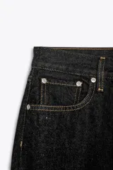Jeans de tiro medio con corte recto, color azul denim con efecto lavado. Cuenta con cinco bolsillos, trabillas en la cintura y cierre frontal con cremallera y botón metálico.