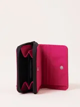 Billetera fucsia con cierre de cremallera y parche de goma negro con logo.