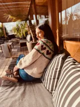 Sweater de punto color gris con diseño de corazones rosas y cuello con diseño geométrico.