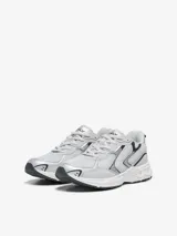 Zapatillas bajas grises con detalles en plateado y negro, con cierre de cordones y suela blanca.