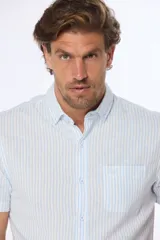 Camisa celeste y blanca a rayas verticales, de lino y algodón, manga corta, corte slim fit, con cuello abotonado y bolsillo en el pecho.