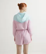 Mono corto deportivo con capucha, en bloques de color rosa y celeste, con cierre frontal naranja.
