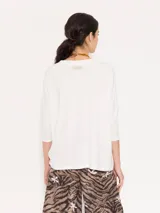 Remera negra de punto liviano con escote en V, mangas 3/4 y recortes diagonales en el delantero.