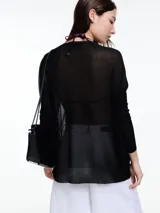 Sweater negro de lurex con escote en V, mangas largas y aberturas laterales.