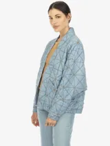 Chaqueta de manga larga estilo kimono, color celeste con diseño geométrico capitoneado y dos bolsillos delanteros.