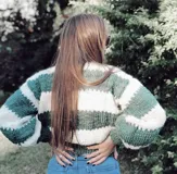 Sweater de lana merino a rayas horizontales en blanco y negro, con cuello alto y mangas largas.