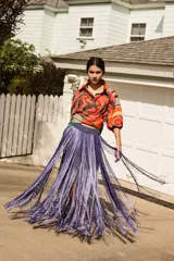 Pollera tejida a mano en crochet con hilado de seda color lila. Diseño con doble capa de flecos largos y elástico en la cintura.