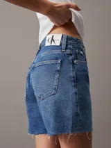 Shorts de jean de tiro alto, color azul medio, con bajo desflecado y diseño de cinco bolsillos.