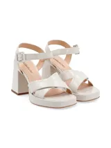 Sandalias de cuero color canela con plataforma y tacón ancho. Tiras cruzadas en el empeine y pulsera ajustable con hebilla en el tobillo.