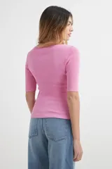 Sweater de punto color beige con rayas horizontales en naranja y blanco, de mangas cortas y cuello redondo.