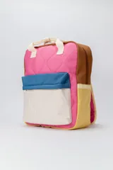 Mochila con diseño capitoneado y bloques de color en rosado, azul, beige, marrón y amarillo. Cuenta con un compartimento principal con cierre, un bolsillo frontal con solapa y cierre, y asas superiores de mano además de las correas de hombro.