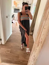 Vestido largo color gris oscuro, con tirantes anchos y un canesú con tejido de punto en tonos coral, turquesa y beige. El vestido tiene un corte holgado y una abertura lateral en la falda.