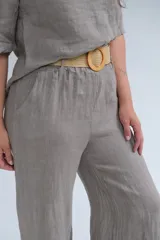Pantalón de lino color visón, de corte recto y tiro medio. Incluye cinturón beige de soga con hebilla circular de madera.
