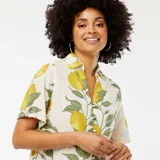 Blusa color crema con estampado de limones y hojas verdes, de manga corta, cuello camisero y cierre frontal con botones.