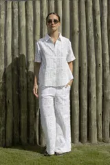 Camisa blanca con diseño calado, de corte recto, cuello camisero y mangas cortas.