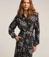 Vestido largo tipo chemise confeccionado en viscolino con estampado floral. Tiene cuello de camisa, mangas largas, abotonadura frontal y lazo en la cintura.