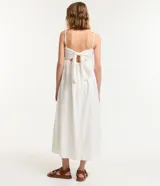 Vestido midi blanco con tirantes finos y escote cuadrado. Presenta bordados de caracolas en el busto y lazo en la espalda.