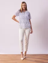 Blusa de microtul estampada con diseño zigzag en tonos celeste y blanco, de la marca Cable & Gauge. Tiene cuello a la base con escote en V y lazo de ajuste, mangas cortas con puño elastizado y forro interno a tono.