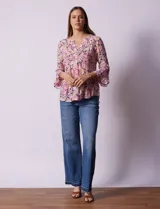 Blusa estampada con flores en tonos rosa, naranja y azul marino. Tiene escote en V con detalle de pliegues y mangas 3/4 con volados.