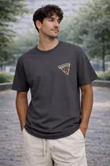 Remera de algodón premium color gris oscuro, con cuello redondo y manga corta. Presenta un pequeño estampado frontal de una porción de pizza con bordes de neón amarillo y rojo.