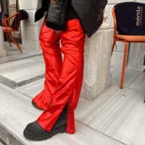 Pantalón rojo brillante de corte acampanado con aberturas laterales con botones a presión.