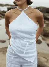 Top blanco de lino con escote halter y lazo en la cintura.