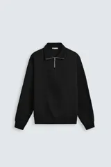 Sudadera negra de cuello alto con cierre frontal de cremallera, corte relaxed fit, manga larga y terminaciones en rib.
