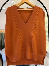 Chaleco de punto color terracota con escote en pico, sin mangas y detalle de trenzas en el frente.