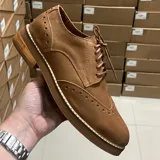 Zapatos Oxford de cuero negro con detalles de perforaciones y cordones.