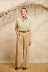 Pantalón ancho color beige de lino con cinto y pretina con elástico en la parte de atrás.