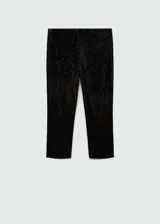 Calzas capri negras cubiertas de lentejuelas, con cintura elástica y corte skinny.