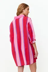 Túnica de manga larga con franjas verticales rosas, rojas y celestes.
